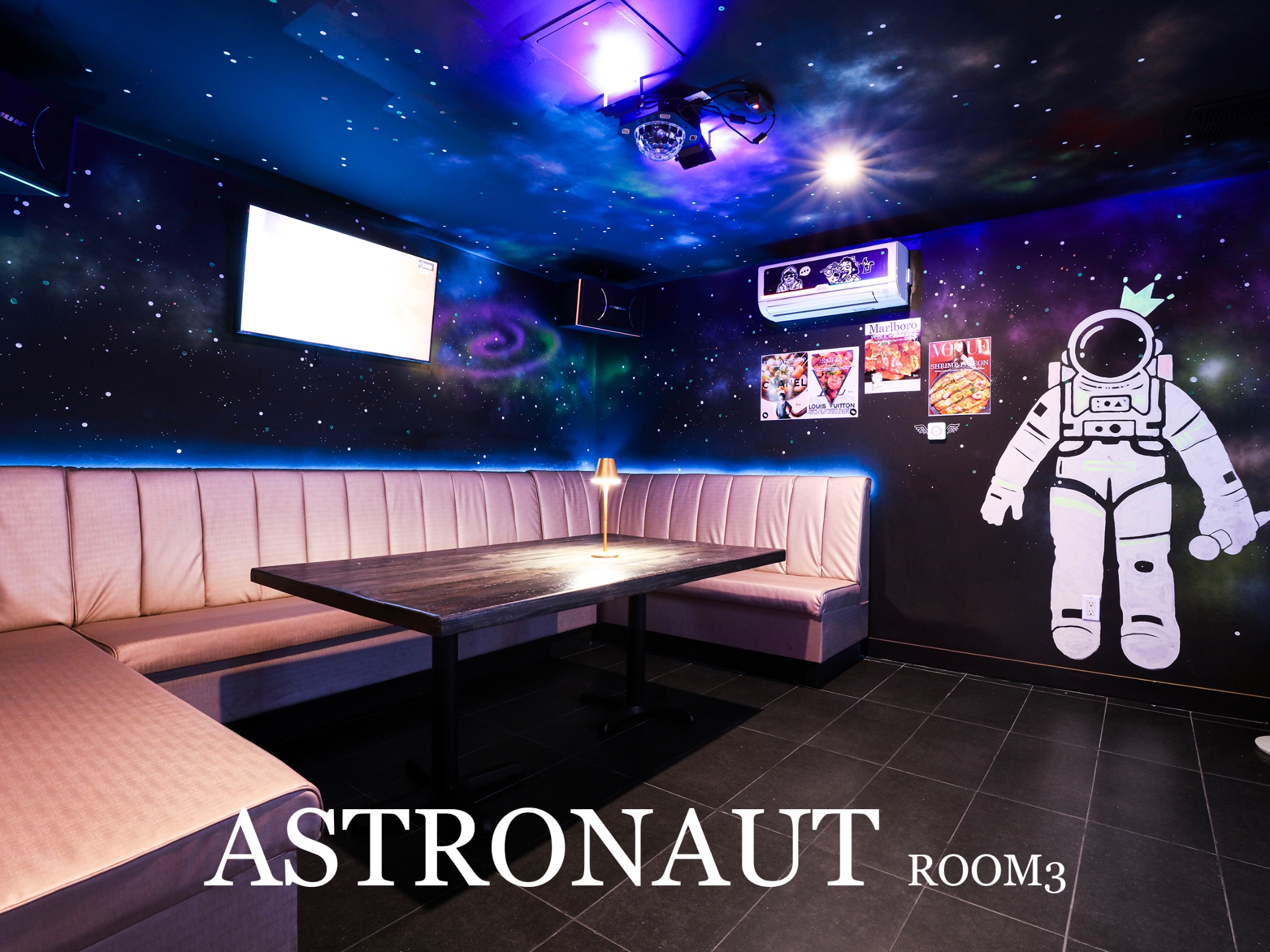 Woobi Karaoke's astronaut-themed private room with wraparound seating and galaxy lighting